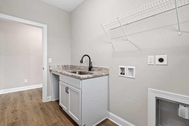 clothes washing area featuring sink, hookup for an electric dryer, washer hookup, and light hardwood / wood-style flooring