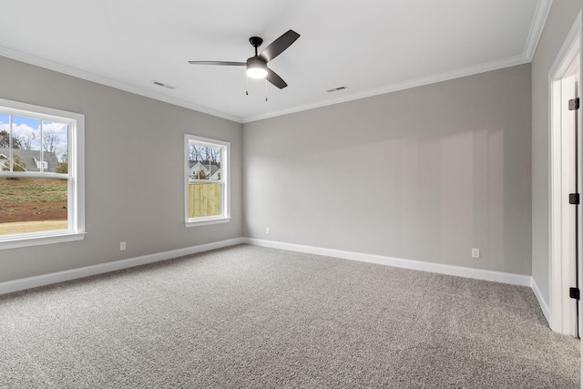 carpeted spare room featuring ceiling fan, a wealth of natural light, and crown molding