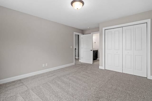 unfurnished bedroom featuring light colored carpet and a closet