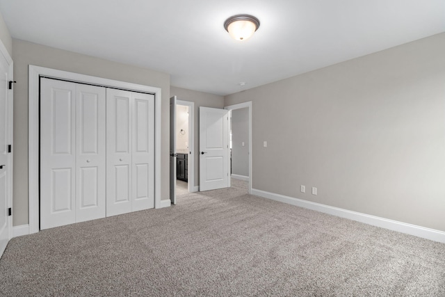 unfurnished bedroom with light colored carpet and a closet