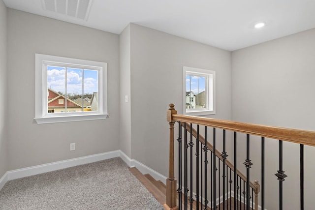 hallway with carpet floors and a wealth of natural light