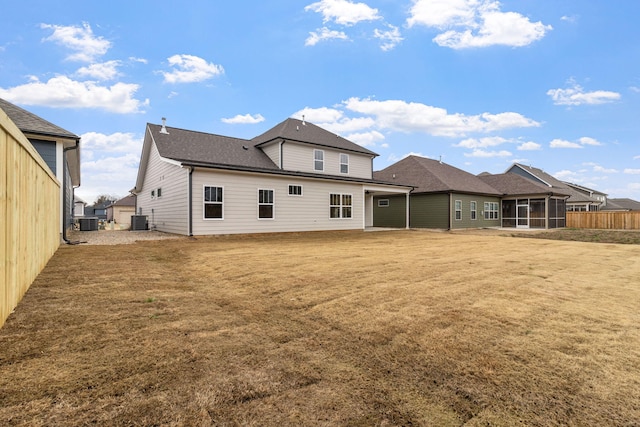 back of property featuring central AC, a yard, and a sunroom