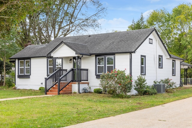 view of front of home with a front lawn and central air condition unit