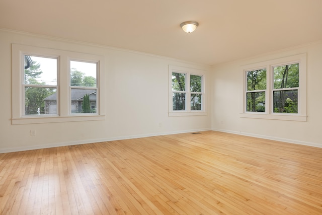 unfurnished room with light hardwood / wood-style flooring, plenty of natural light, and ornamental molding