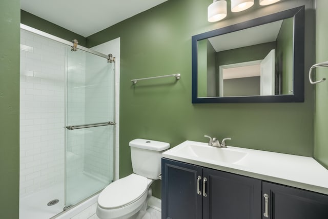 bathroom featuring vanity, toilet, and a shower with door