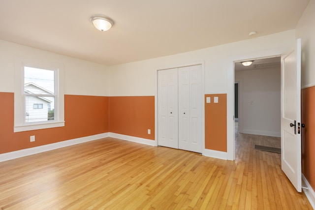 unfurnished bedroom with light wood-type flooring and a closet