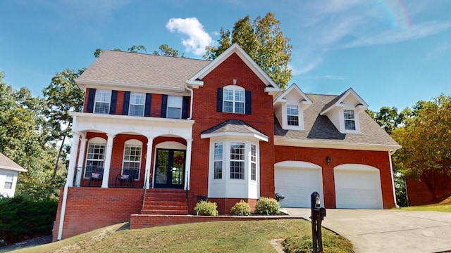 view of front of house with a front yard, a garage, and a porch