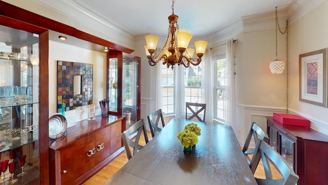 dining area featuring an inviting chandelier, crown molding, and light hardwood / wood-style floors