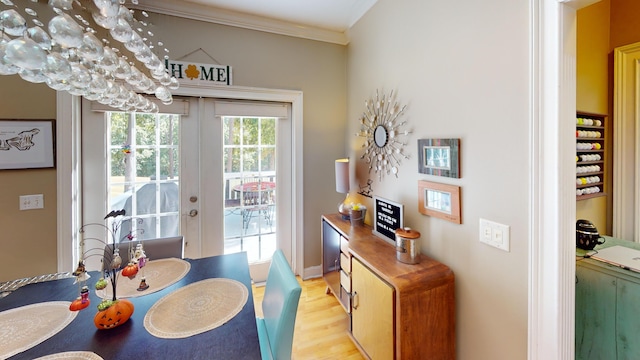 dining room with french doors, light hardwood / wood-style flooring, and crown molding