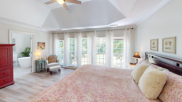 bedroom with light wood-type flooring, vaulted ceiling, connected bathroom, crown molding, and ceiling fan