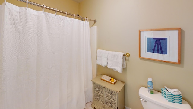 bathroom featuring toilet and a shower with shower curtain