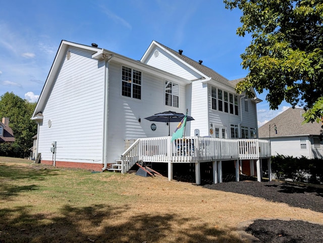 back of house featuring a deck and a yard