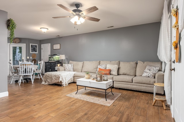 living room with ceiling fan and wood-type flooring