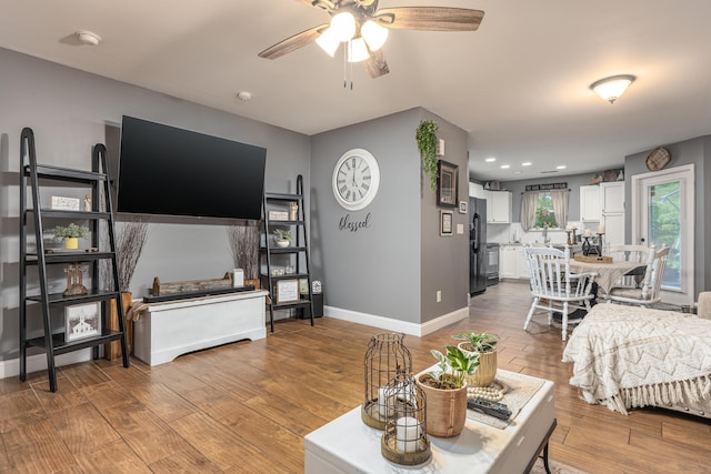 living room featuring light hardwood / wood-style floors and ceiling fan