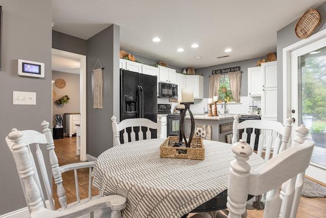 dining room with sink and light hardwood / wood-style flooring