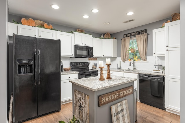 kitchen featuring white cabinets, light hardwood / wood-style flooring, sink, and black appliances