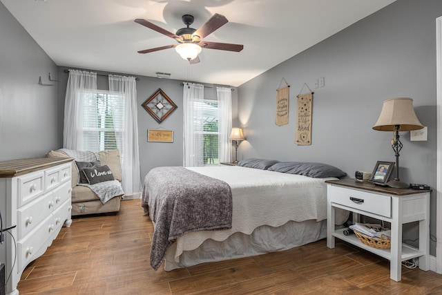 bedroom with ceiling fan, hardwood / wood-style floors, and multiple windows