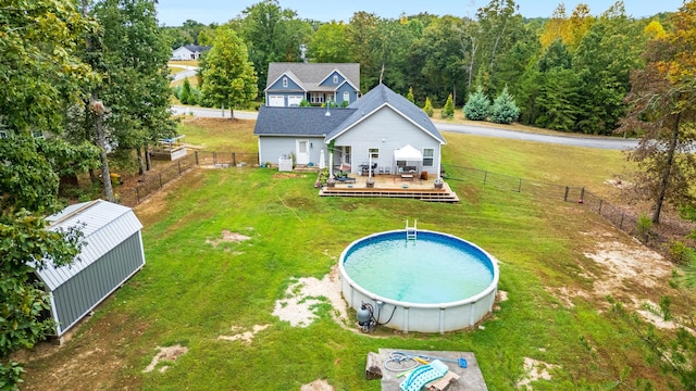 back of property featuring a pool side deck and a yard