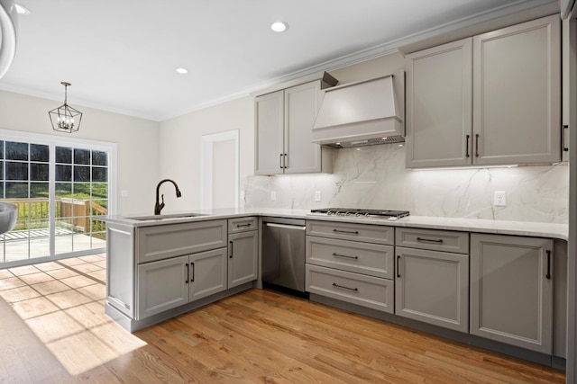 kitchen with stainless steel appliances, sink, custom range hood, backsplash, and pendant lighting