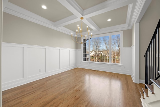 unfurnished dining area with coffered ceiling, wood-type flooring, beamed ceiling, ornamental molding, and an inviting chandelier