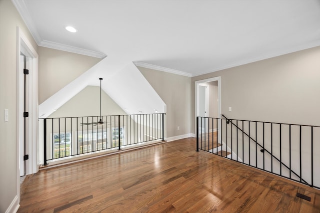 unfurnished room with ceiling fan, vaulted ceiling, crown molding, and hardwood / wood-style flooring