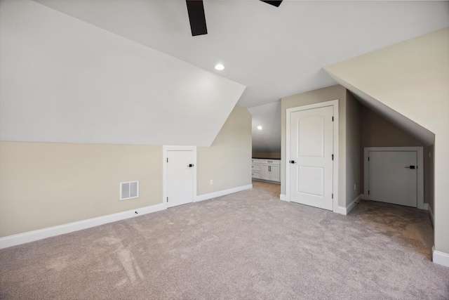 additional living space featuring lofted ceiling and light carpet