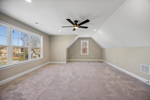 additional living space with lofted ceiling, light carpet, and ceiling fan