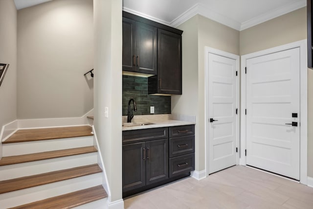 kitchen featuring sink, crown molding, and backsplash