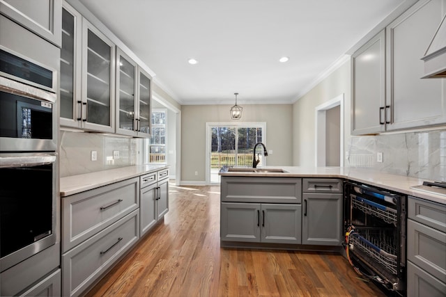 kitchen with ornamental molding, dark hardwood / wood-style floors, gray cabinets, and decorative backsplash