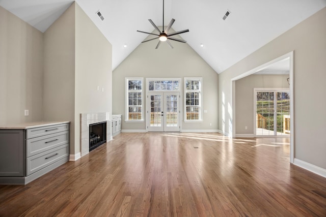 unfurnished living room with high vaulted ceiling, ceiling fan, and dark hardwood / wood-style floors