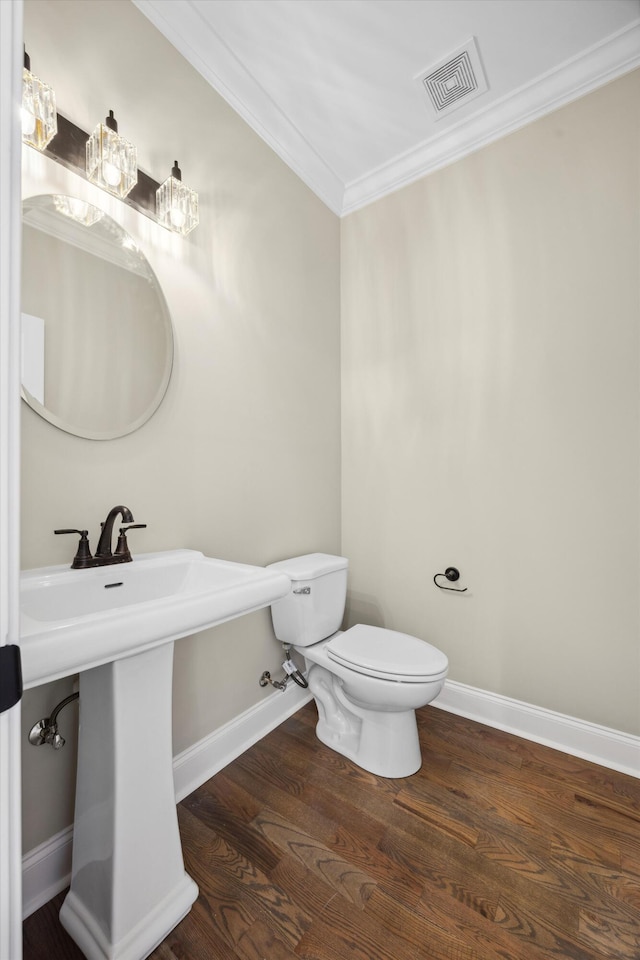 bathroom featuring toilet, hardwood / wood-style flooring, crown molding, and sink