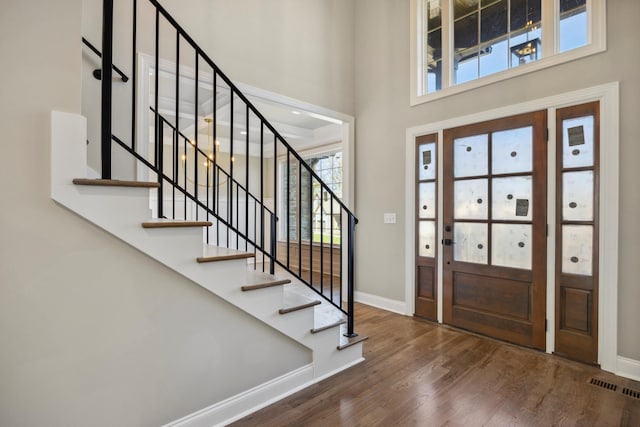 foyer entrance with a high ceiling and dark hardwood / wood-style floors