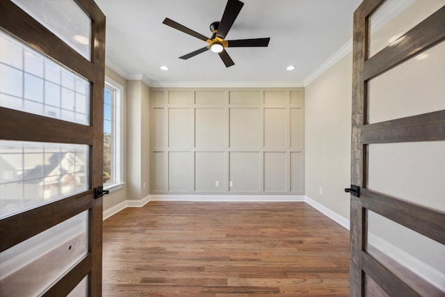 spare room featuring ceiling fan, hardwood / wood-style flooring, and crown molding