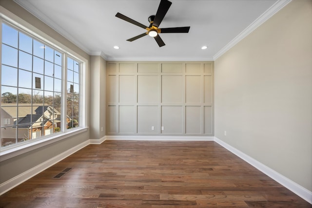 empty room with ornamental molding, a healthy amount of sunlight, and dark hardwood / wood-style floors