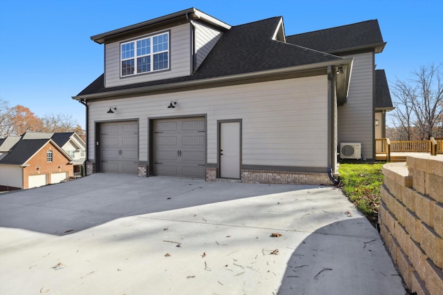 view of side of home with ac unit and a garage