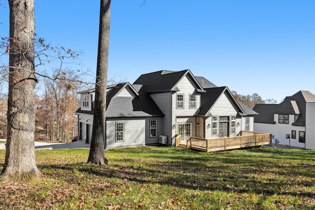 back of property with a yard, a garage, and a wooden deck