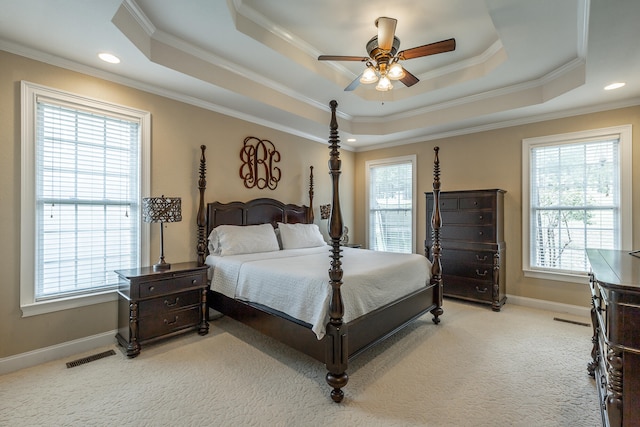 carpeted bedroom with ceiling fan, a raised ceiling, and crown molding