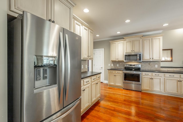 106 Woodpecker Pl, Ringgold, GA 30736 - kitchen with tasteful backsplash, ornamental molding, dark countertops, appliances with stainless steel finishes, and cream cabinetry