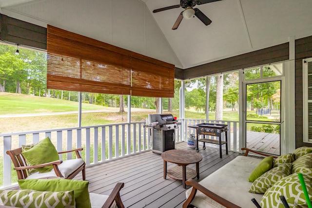 sunroom / solarium featuring ceiling fan, vaulted ceiling, and a healthy amount of sunlight