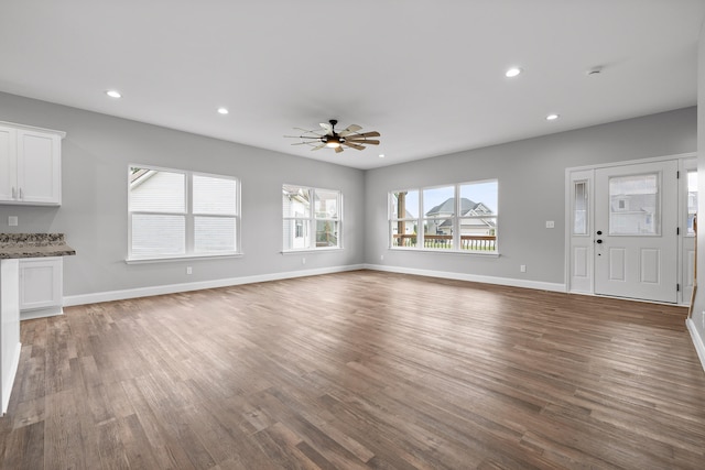 unfurnished living room with ceiling fan and hardwood / wood-style floors