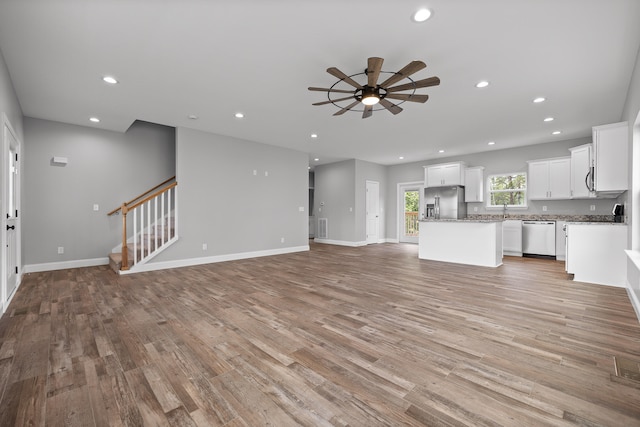 unfurnished living room with ceiling fan and light hardwood / wood-style flooring