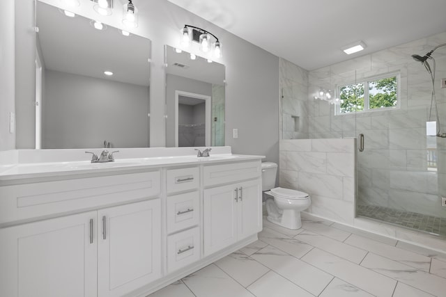 bathroom with vanity, toilet, and a shower with door