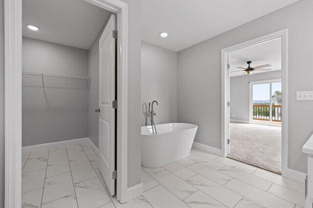 bathroom with ceiling fan and a bath