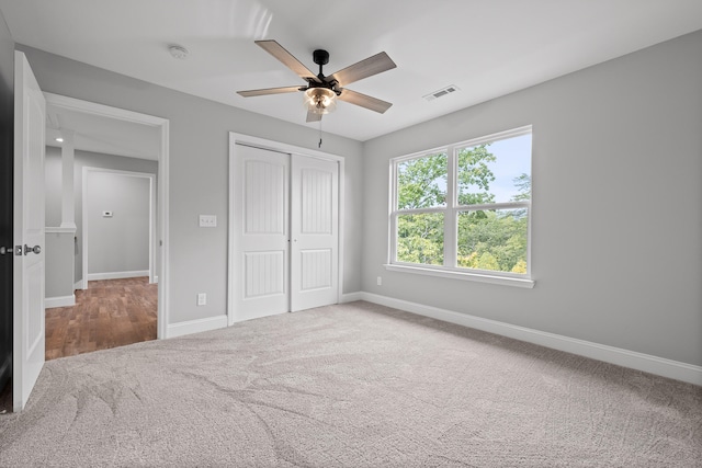 unfurnished bedroom featuring a closet, ceiling fan, and carpet flooring