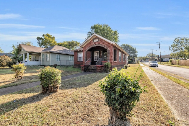 bungalow featuring a front yard and covered porch