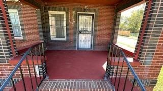 view of exterior entry featuring covered porch