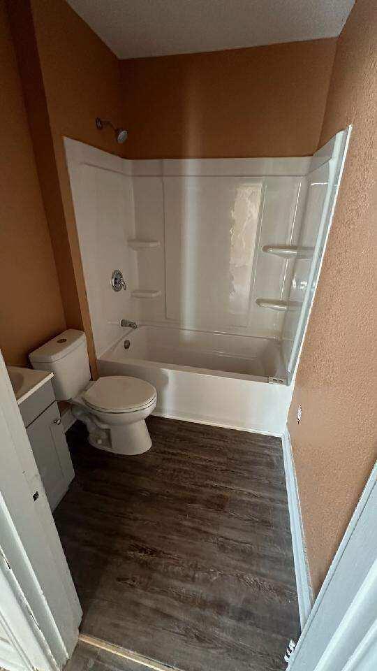 full bathroom featuring vanity, toilet, shower / washtub combination, and hardwood / wood-style floors