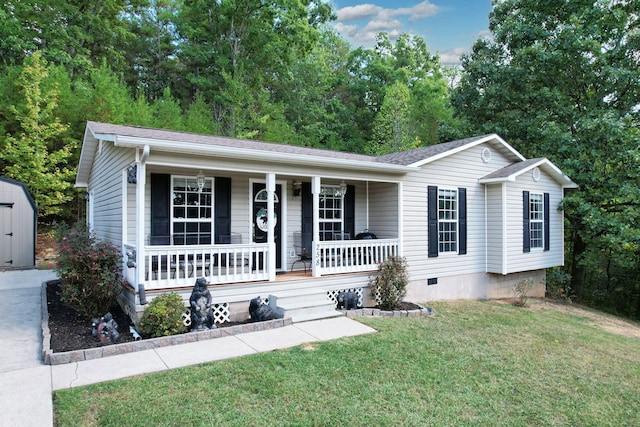 view of front of house featuring a front yard, a storage unit, and covered porch