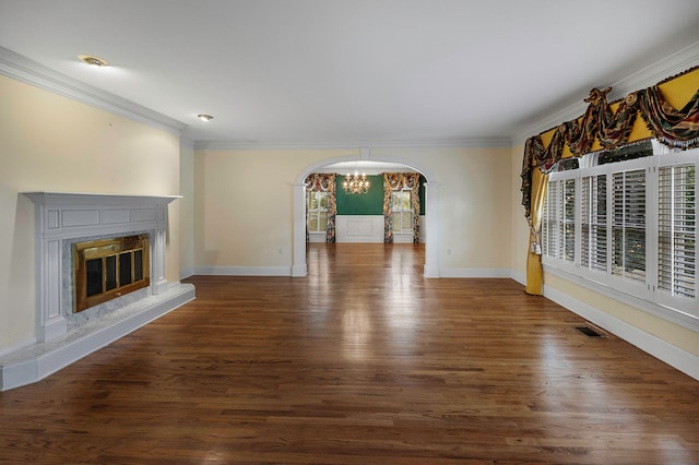 unfurnished living room with a wealth of natural light, a high end fireplace, crown molding, and dark hardwood / wood-style flooring