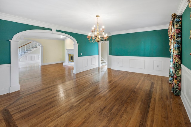 spare room with ornamental molding, hardwood / wood-style floors, and a notable chandelier